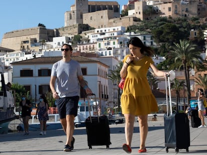 Dos personas con maletas caminan por Ibiza, el pasado 26 de junio.