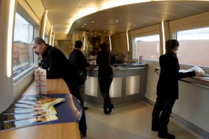 Viajeros del AVE Madrid-Valencia en la cafetería del tren durante el trayecto.