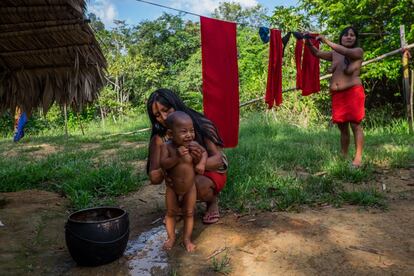 Mãe dá banho em filho Wajãpi.