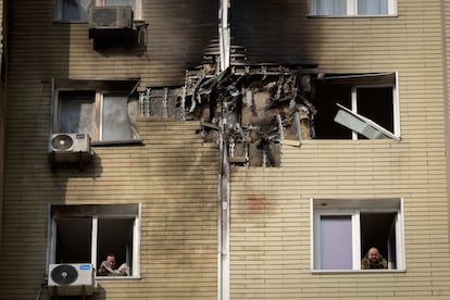 Residentes limpian los destrozos causados en sus viviendas tras un ataque ruso esta madrgada, en Kiev. 