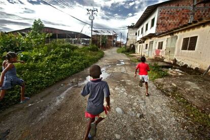 Varios niños corren por una calzada colombiana.