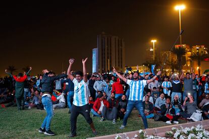 Seguidores de Argentina en las calles de Doha (Qatar) festejan mientras ven la transmisión en una pantalla gigante.