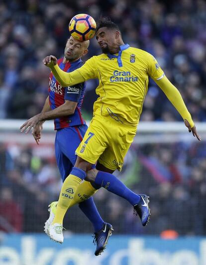 Javier Mascherano (i), del Barcelona, y Kevin-Prince Boateng, de Las Palmas, golpean el balón de cabeza.