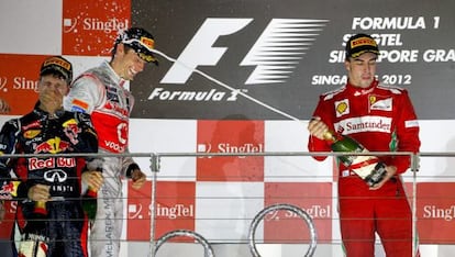 Fernando Alonso (right) sprays race winner Sebastian Vettel to Jenson Button&rsquo;s amusement. 