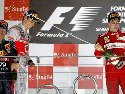 Fernando Alonso (right) sprays race winner Sebastian Vettel to Jenson Button&rsquo;s amusement. 