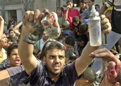 Un palestino muestra con rabia los zapatos y el biberón de la pequeña muerta en el ataque.