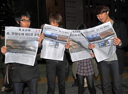Surcoreanos leen las ediciones extra de los periódicos que recogen el ataque de Corea del Norte.