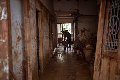 Un residente limpia el barro de su casa, gravemente afectada por las inundaciones en Masanasa, este miércoles.