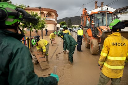 Varios efectivos del Infoca limpian las calles de barro de la Barriada Doña Ana de la localidad de Cartama, Málaga, este miércoles.