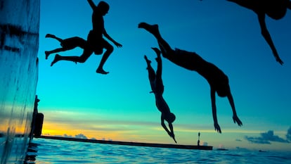Varios jóvenes disfrutan de un chapuzón en aguas de Maldivas.