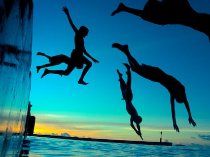 Varios jóvenes disfrutan de un chapuzón en aguas de Maldivas.