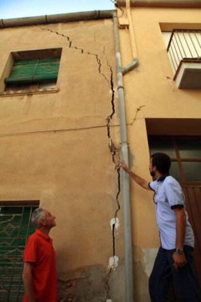 Unos vecinos de Barberà de la Conca observan la grieta de su casa.