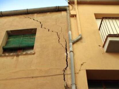 Unos vecinos de Barberà de la Conca observan la grieta de su casa.