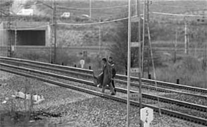 Dos toxicómanos cruzan la vía, en Pitis, para ir a comprar droga al pobaldo de La Quinta, en una imagen de archivo.