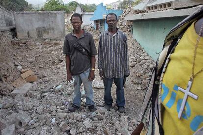 Los hermanos Agoustin y André Jean Charles, enterradores del cementerio de Route Frère, junto a una fosa común.