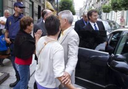 Dos afectadas por las preferentes se dirigen al presidente de la Xunta de Galicia, Alberto Núñez Feijóo (d), a su la salida de la IV Conferencia Mundial de las conservas de pescados y mariscos que se celebra en Vigo.