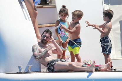 Messi juga amb els nens, que el ruixen amb aigua a la coberta del vaixell.