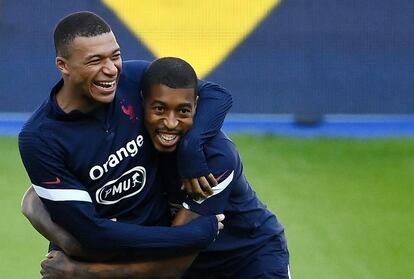 Kylian Mbappe abraza a su compañero Presnel Kimpembe durante el entrenamiento de este lunes antes de conocer su positivo.