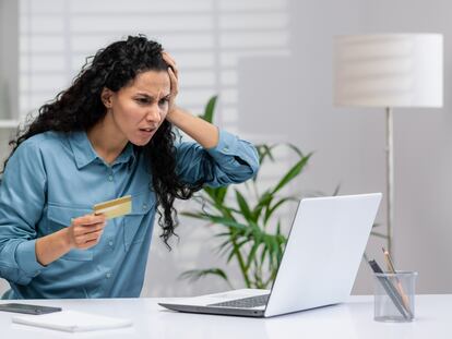 Una mujer frustrada tras usar su tarjeta de crédito en línea, en una fotografía ilustrativa.