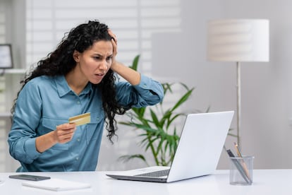 Una mujer frustrada tras usar su tarjeta de crédito en línea, en una fotografía ilustrativa.