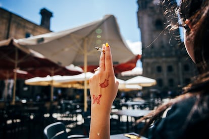 Una mujer fuma un cigarrillo en una terraza en Santiago de Compostela (A Coruña) el 26 de junio de 2025