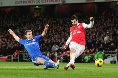 Cesc Fabregas, del Arsenal, dispara ante la oposición de Branislav Ivanovic, del Chelsea.