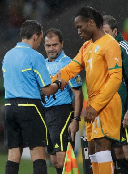 El arbitro hungaro  Victor Kassai examina la férula de Drogba antes de que éste entre en el campo.