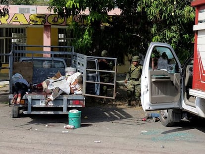 Soldados inspeccionan la escena de un tiroteo en Apatzing&aacute;n (M&eacute;xico).