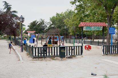 Una familia juega en la área infantil del parque de la Cornisa, Madrid.