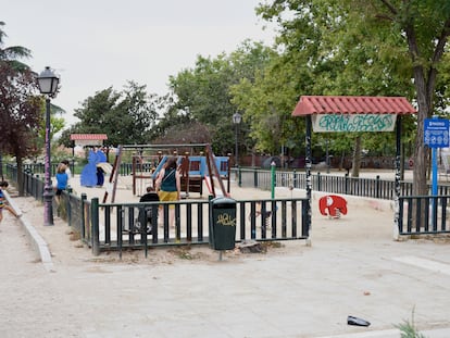 Una familia juega en la área infantil del parque de la Cornisa, Madrid.