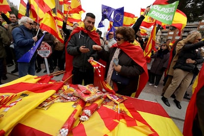 Uma mulher compra bandeiras perto da praça de Colón de Madri, neste domingo.