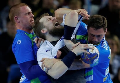 Kari Kristjan Kristjansson, de la selección de balonmano de Islandia, es bloqueado por dos jugadores del equipo esloveno en un partido del Campeonato Mundial de Balonmano, celebrado en Metz (Francia).