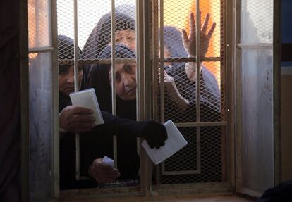 Un grupo de mujeres esperan, detrás de una ventana, recibir sus tarjetas electrónicas en Bagdad (Irak) para poder votar en las próximas elecciones legislativas que se celebrarán en abril.