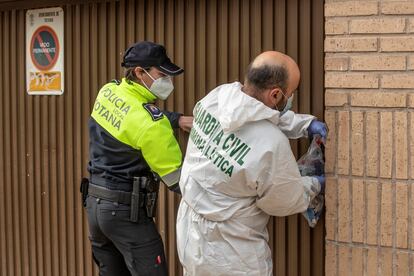 Un agente de la unidad criminalística de la Guardia Civil y uno de la Policía Local de Totona cierran la puerta del garaje que da acceso al trastero donde se encontraba el cadáver de la joven.