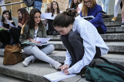 Estudiantes repasando sus apuntes a la entrada de la Universidad