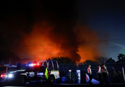 Policías municipales montan guardia cerca de la zona de un incendio en Santa Catarina, Nuevo León. 