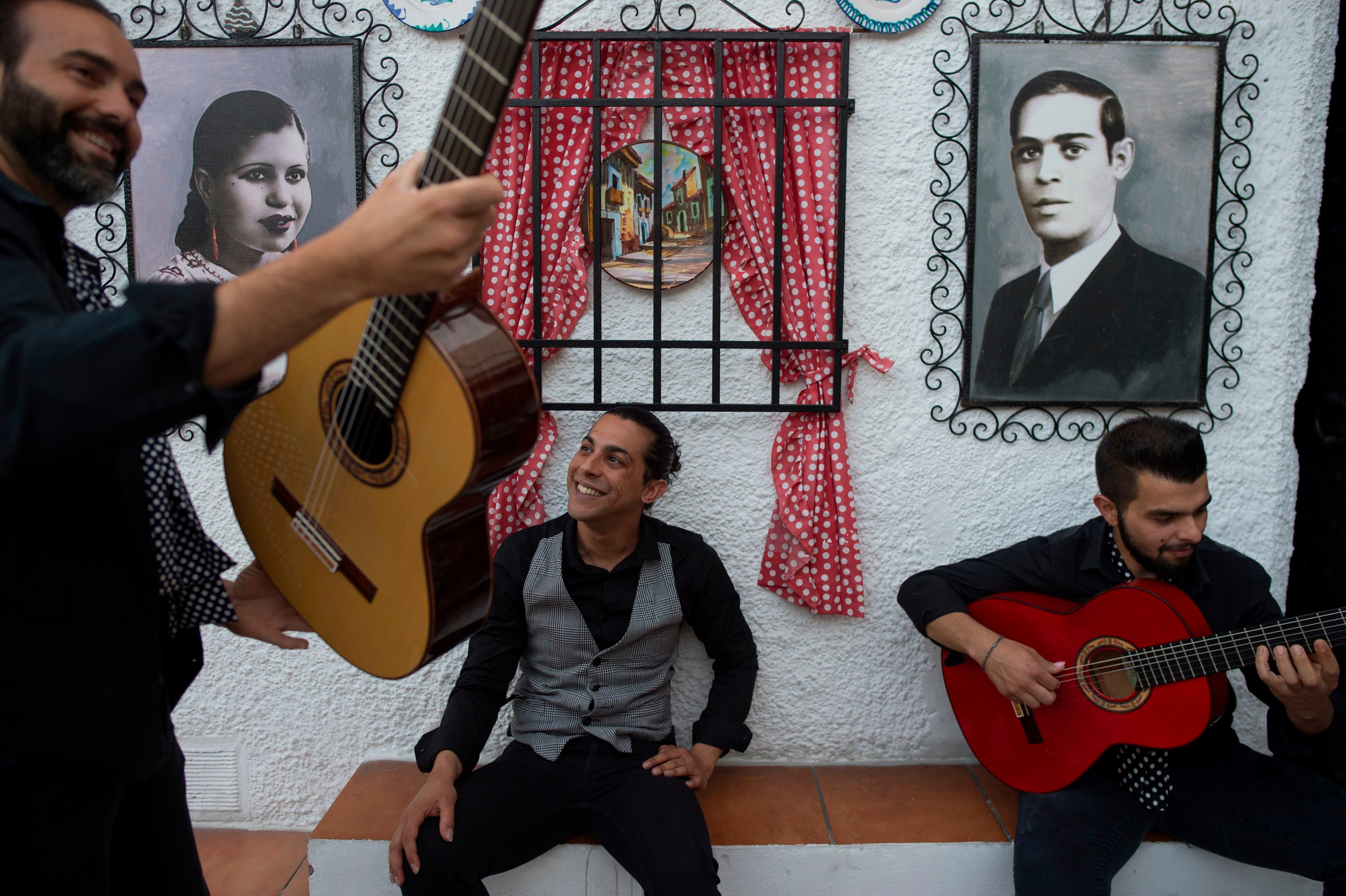 Guitarristas flamencos conversan mientras se preparan para un espectáculo de danza en el barrio del Sacromonte, en Granada.