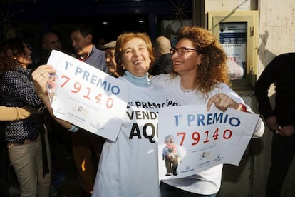 Unas mujeres se felicitan con las copias del número 79.140, agraciado con el Gordo de Navidad vendido íntegramente en la administracion nº 2 de Roquetas de Mar, Almería.