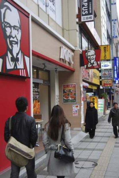 Japón, un país sin tradición cristiana, comenzó a desarrollar hace cuatro décadas una peculiar costumbre navideña que a día de hoy lleva a millones de familias niponas a compartir un cuenco de pollo frito para cenar en Nochebuena. En la imagen, un establecimiento KFC en Tokio anuncia en el exterior del local dos nuevos menús especiales de Nochebuena.