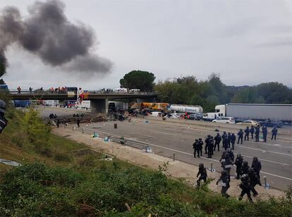 Agents de la Policia Nacional i els Mossos d'Esquadra, durant el desallotjament de l'AP-7 a Salt (Gironès), aquest dimecres.