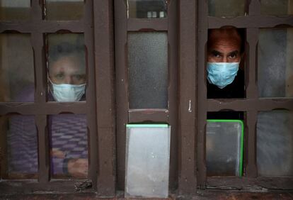 Dos pacientes con coronavirus miran por una ventana de un módulo de aislamiento el Hospital Mental Víctor Larco Herrera, en Lima (Perú). 