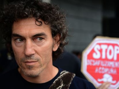 El bombero y activista Roberto Rivas, ante un cartel antidesahucios