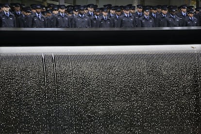 Bomberos en prácticas se mantienen firmes frente al memorial del 11-S durante ceremonia floral ante el monumento de Nueva York (EE UU).