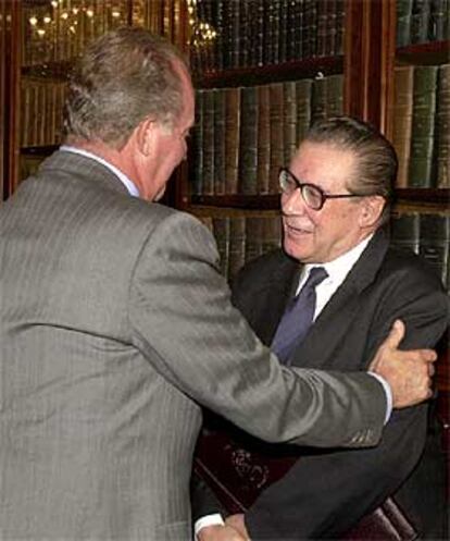 Don Juan Carlos felicita al economista Velarde en el acto de ayer.