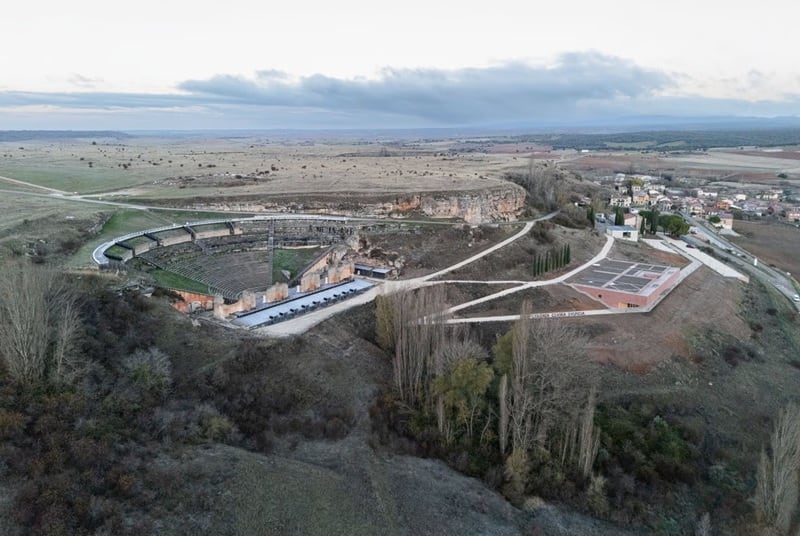 Vista aérea del teatro romano de Clunia Sulpicia, el nuevo centro de visitantes y, al fondo, Peñalba de Castro (Burgos).