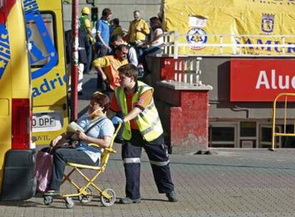 Una mujer herida es conducida a una ambulancia tras ser atendida en el hospital de campaña que se aprecia al fondo.