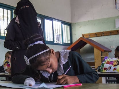 Doaa, con la mano vendada, hace los deberes en el colegio.
