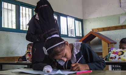 Doaa, con la mano vendada, hace los deberes en el colegio.