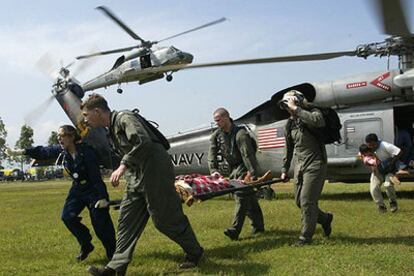 Soldados norteamericanos del portaaviones <i>Abraham Lincoln</i> trasladan a un indonesio herido por el maremoto tras su rescate en helicóptero.