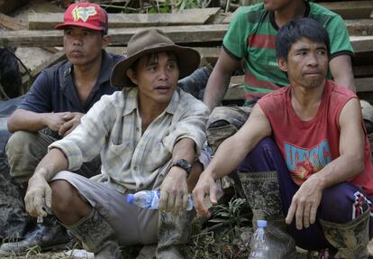 Mineros filipinos descansan de las labores de búsqueda de víctimas por el desprendimiento de tierra en la mina de Itogon.